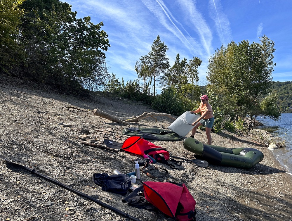 Inflando un packraft en la orilla del lago durante una aventura de packrafting en el Eifel alemán